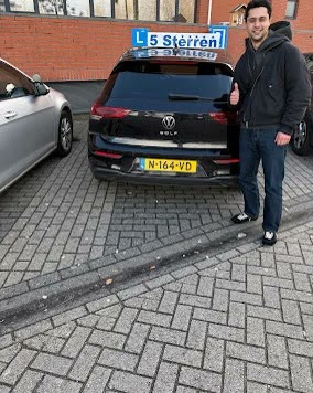 Geslaagde leerling naast de lesauto van Rijschool 5 Sterren