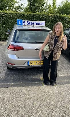 Geslaagde leerling met de lesauto van Rijschool 5 Sterren