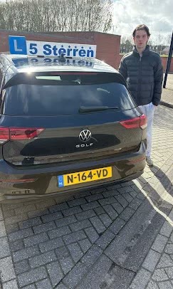 Geslaagde leerling naast de lesauto van Rijschool 5 Sterren in Amsterdam