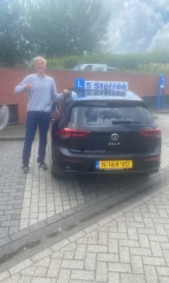 Geslaagde leerling bij de lesauto van Rijschool 5 Sterren